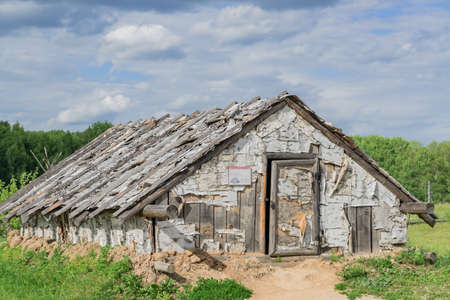wooden house at the edge of the forest under dramatic skyの写真素材
