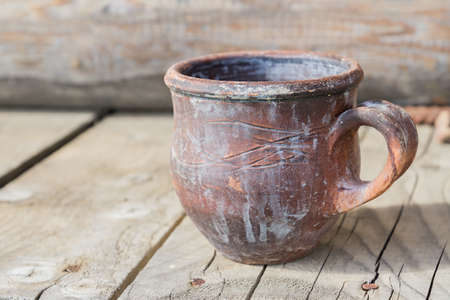 old rusty iron cup on wooden backgroundの写真素材