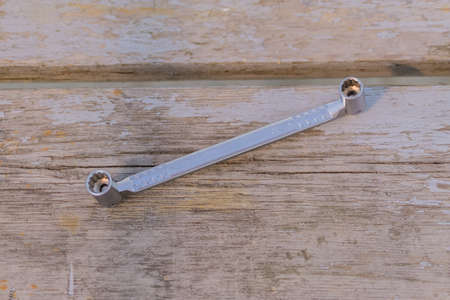 top view of metal socket wrench on wooden background. worktool for maintenance and repair