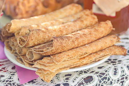 Russian pancakes rolled on a plate, close up