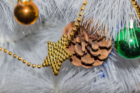 holidays, new year and celebration concept - white Christmas tree. golden and blue garland, pine cone, green and golden ballsの写真素材