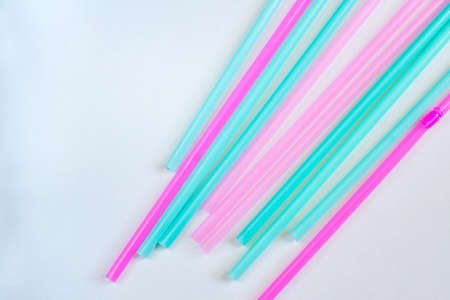 pink and blue straws for coctails and other long drinks on white background
