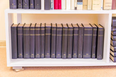 old books on a white shelf in the library