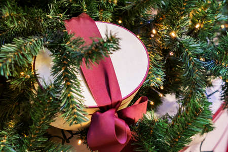 Christmas and New Year holidays background. Christmas tree with garland and giftbox with a bow