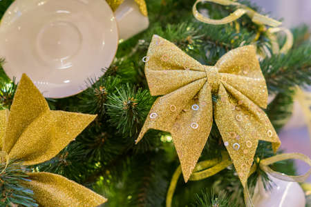 Christmas and New Year holidays background. Christmas tree decorated with white cups ans sauces and golden bows. Trendy conceptの写真素材