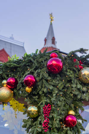 Christmas tree branches decorated with balls and garlands on red square background in Moscowの写真素材