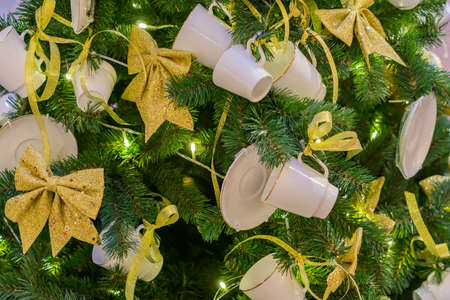 Christmas and New Year holidays background. Christmas tree decorated with white cups ans sauces. Trendy conceptの写真素材