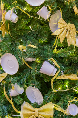 Christmas and New Year holidays background. Christmas tree decorated with white cups ans sauces....