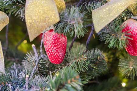 Christmas and New Year holidays background. Christmas tree decorated with strawberry, selective focus. Celebration conceptの写真素材