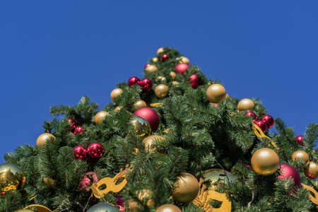 Christmas and New Year holidays background. Christmas tree decorated with balls and garlands against blue sky, bottom viewの写真素材