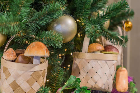 Christmas and New Year holidays background. Christmas tree decorated with basket with mushrooms and cabbage. Celebration conceptの写真素材