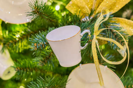 Christmas and New Year holidays background. Christmas tree decorated with white cups ans sauces. Trendy conceptの写真素材