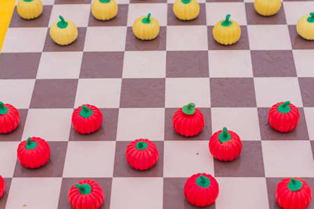 close up of checkered board with pumpkin checkers, colorful backgroundの写真素材