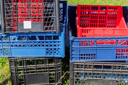 Set of multicolored plastic boxes in the garden. Container for harvest