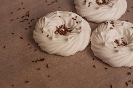 homemade white air meringues and confectionery decorations on on parchment paper.の写真素材