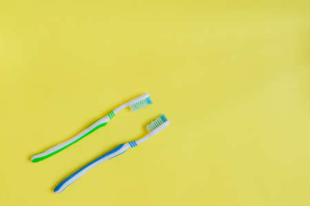 Two toothbrushes on yellow background. Top view, minimal flat lay.の写真素材