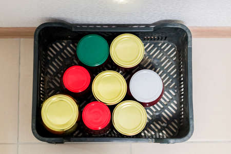top view of winter preserves - jars of pickled vegetables and fruits in plastic box on the floor