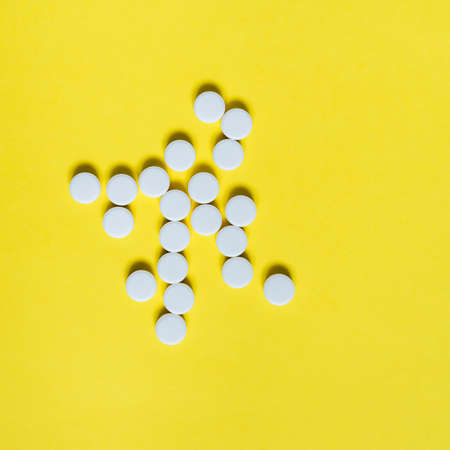 white medicine pills on yellow background. Medical and healthcare conceptの写真素材