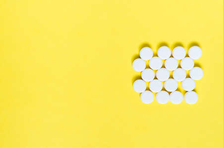 white medicine pills on yellow background. Medical and healthcare conceptの写真素材