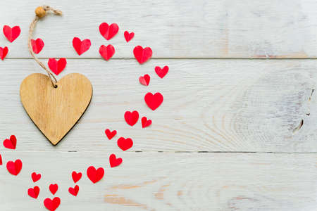 Big red heart made of cut out paper small hearts on wooden backround. Handmade decoration for...