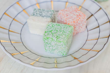 Traditional turkish delight on a plate on white wooden background. Assorted Oriental sweets.の写真素材