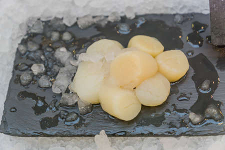 Fresh seafood - scallops - displayed on ice grocery store. Selective focus.の写真素材