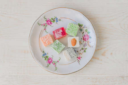 Traditional turkish delight on a plate. Assorted Oriental sweets. Top view.