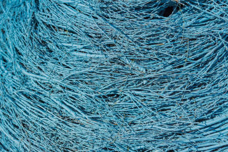 blue background of thin dry twigs. Wicker fence texture