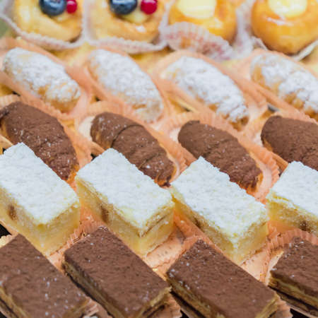 Pastry shop display window with variety of mini desserts and cakes, selective focusの写真素材