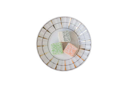 Traditional turkish delight on a plate on white background. Assorted Oriental sweets. Top