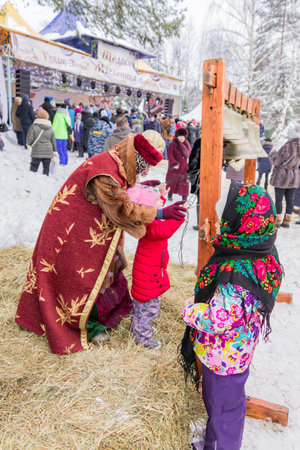 Moscow Region, Russia - February 18, 2018: Celebration of Russian Shrovetide. Children playing bellsaのeditorial素材