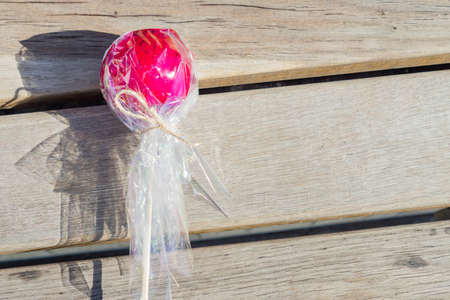 close up of red caramel apple on wooden background. Sweet dessert from street fairの写真素材