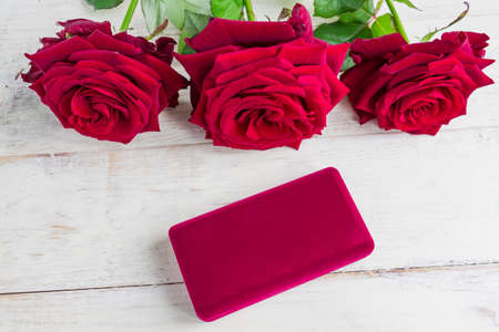 jewelry gift box and bautiful red roses on wooden background.の写真素材