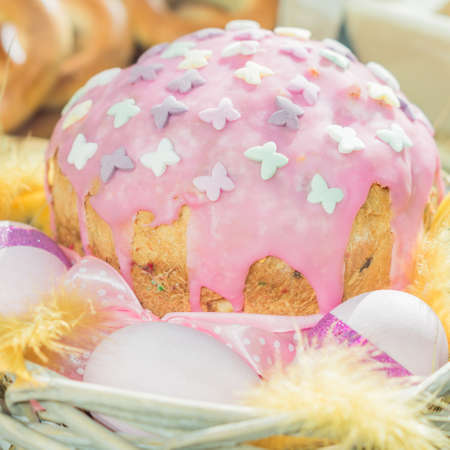 Close up of easter cake with glaze and colored eggs in pink colors.