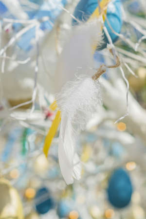 colorfull easter egg tree. brights eggs and tender feathers hanging from branches.の写真素材