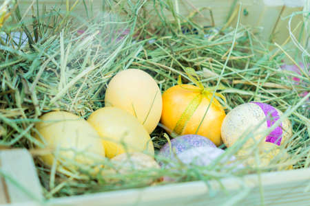 Colorful painted easter eggs in hay nest. Easter celebration decor