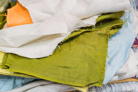 Stack of natural fabrics and textiles lie at a market stand. Sewing industry conceptの写真素材