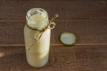 Open bottle of fresh milk on wooden background. Natural dietary product.の写真素材
