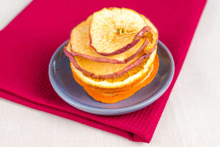 Healthy food organic nutrition. Sliced and dried apple, orange on textile background.
