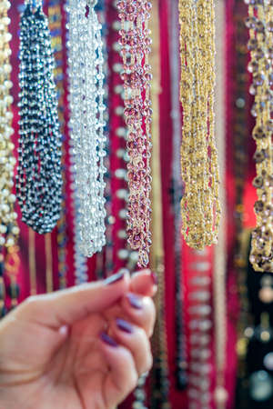 Woman choosing colorful crystal beads necklaces. Background pattern. Handicraft fashionable for...