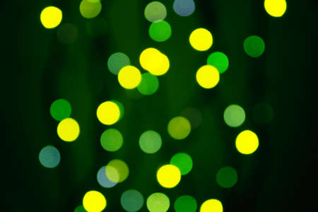 abstract blurred lights on background in green and yellow- christmas celebration conceptの写真素材