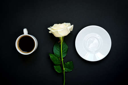 Cup of black coffee and white rose on black background, Top view, copy space.の写真素材
