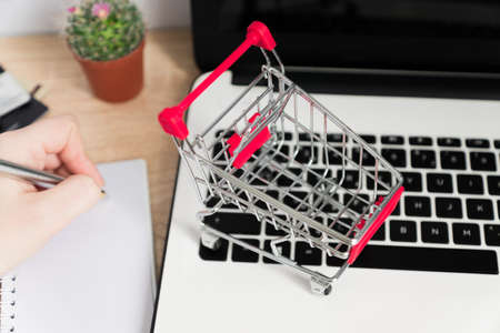 Small red shopping cart or trolley on laptop keyboard, Technology business online shopping conceptの写真素材