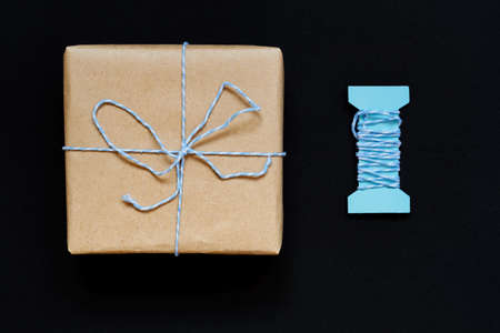 Handcrafted gift box wrapped in Craft paper with blue ribbon and bowの写真素材