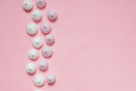 white and pink twisted meringues in a shape of pyramid on pink background, greeting card, copy spaceの写真素材