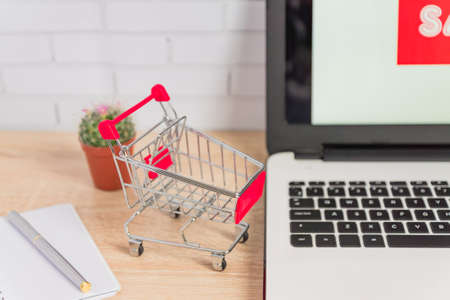 Small red shopping cart or trolley on laptop keyboard, Technology business online shopping conceptの写真素材