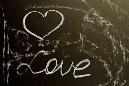 A chalk board with the word love and a heart. Grunge background textureの写真素材