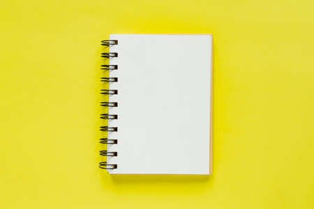 Clean note book for goals and resolutions. mockup for your design. Spiral note book on yellow background.の写真素材