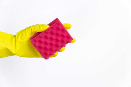 hand with yellow glove holding red sponge for cleaning on white backgroundの写真素材