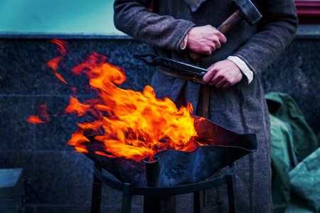 Blacksmith workshop on the street. People in traditional clothses forge metalの写真素材